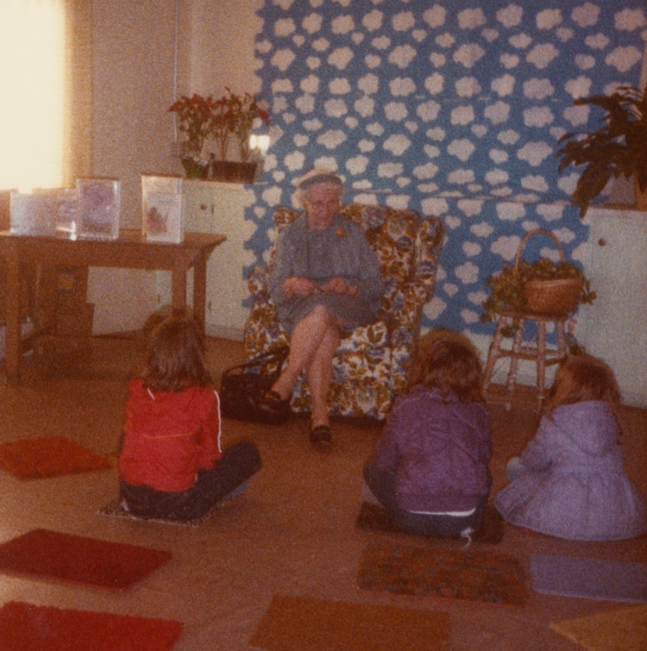 An image depicting Mary Alice White, a former Occident Club president, reading to children.
