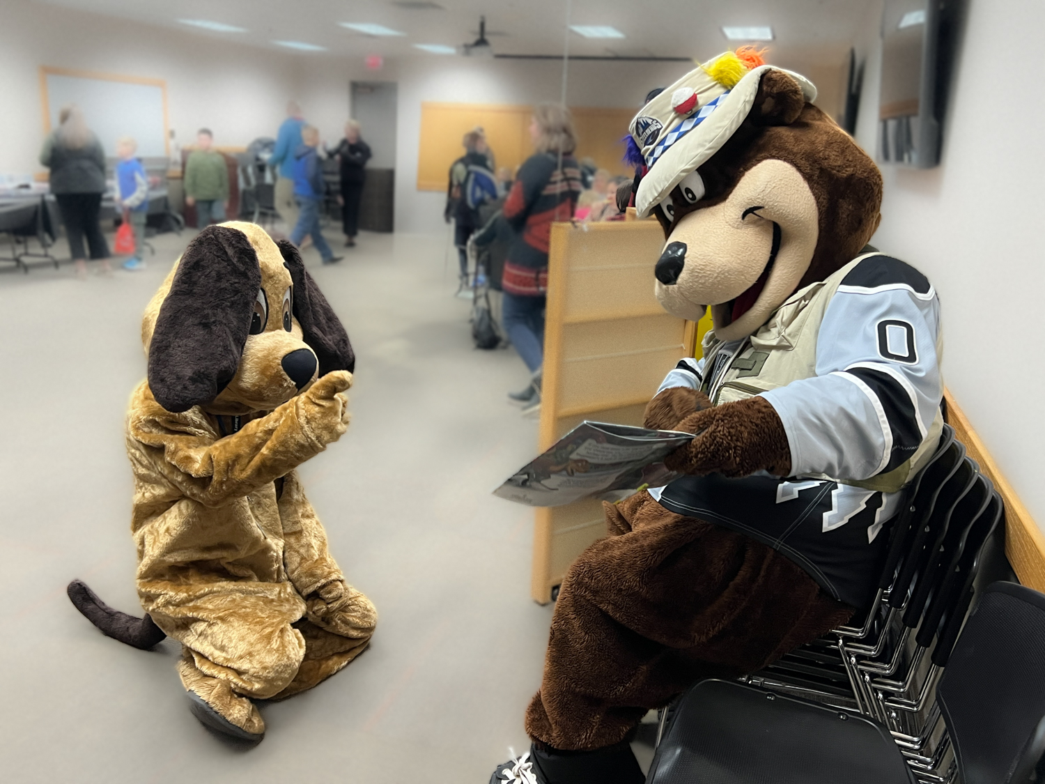 Mascots Rascal and Blue reading a book